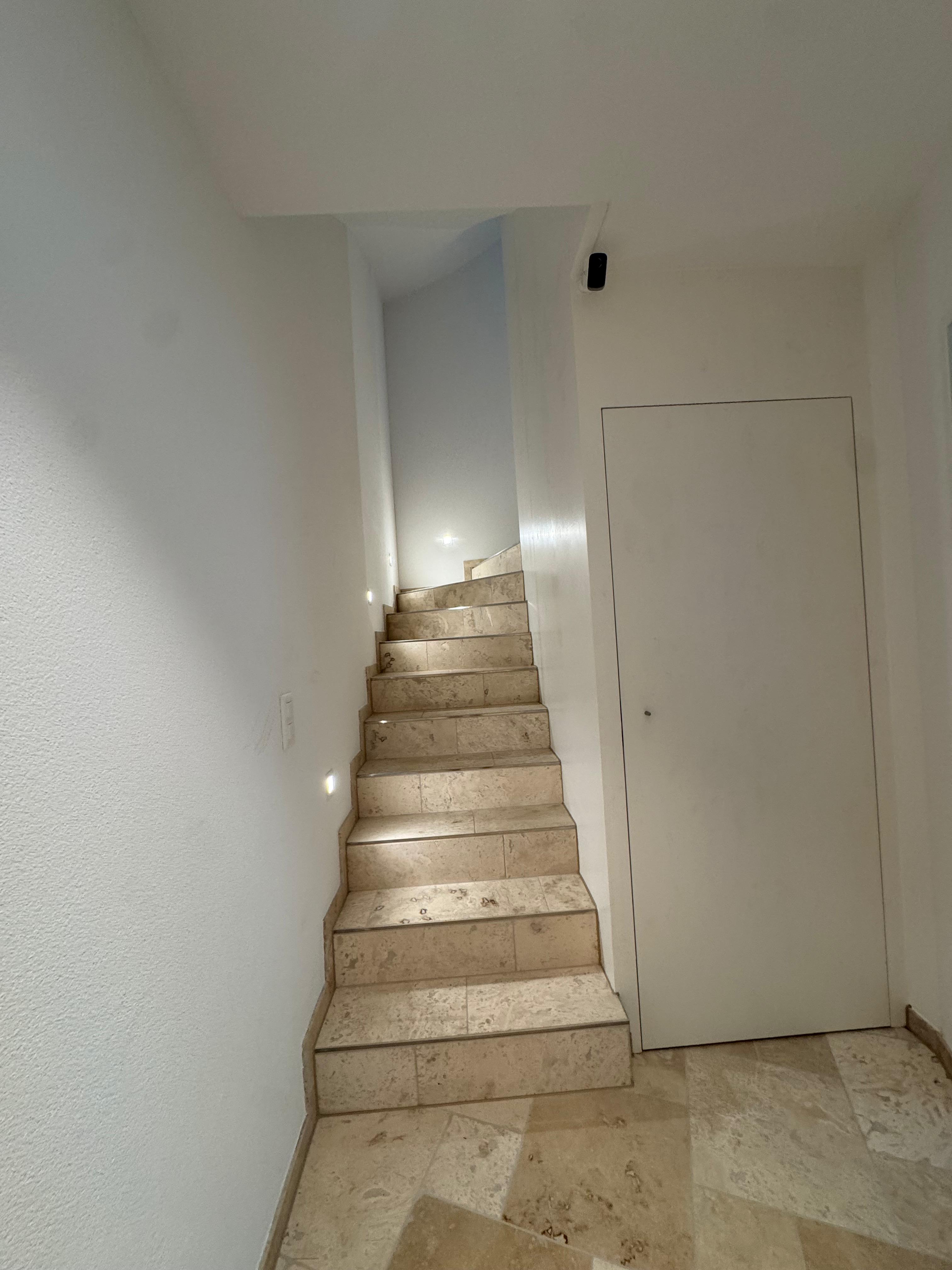 Travertine hallway and staircase at Villa 77, furnished private house near Baden, Aargau