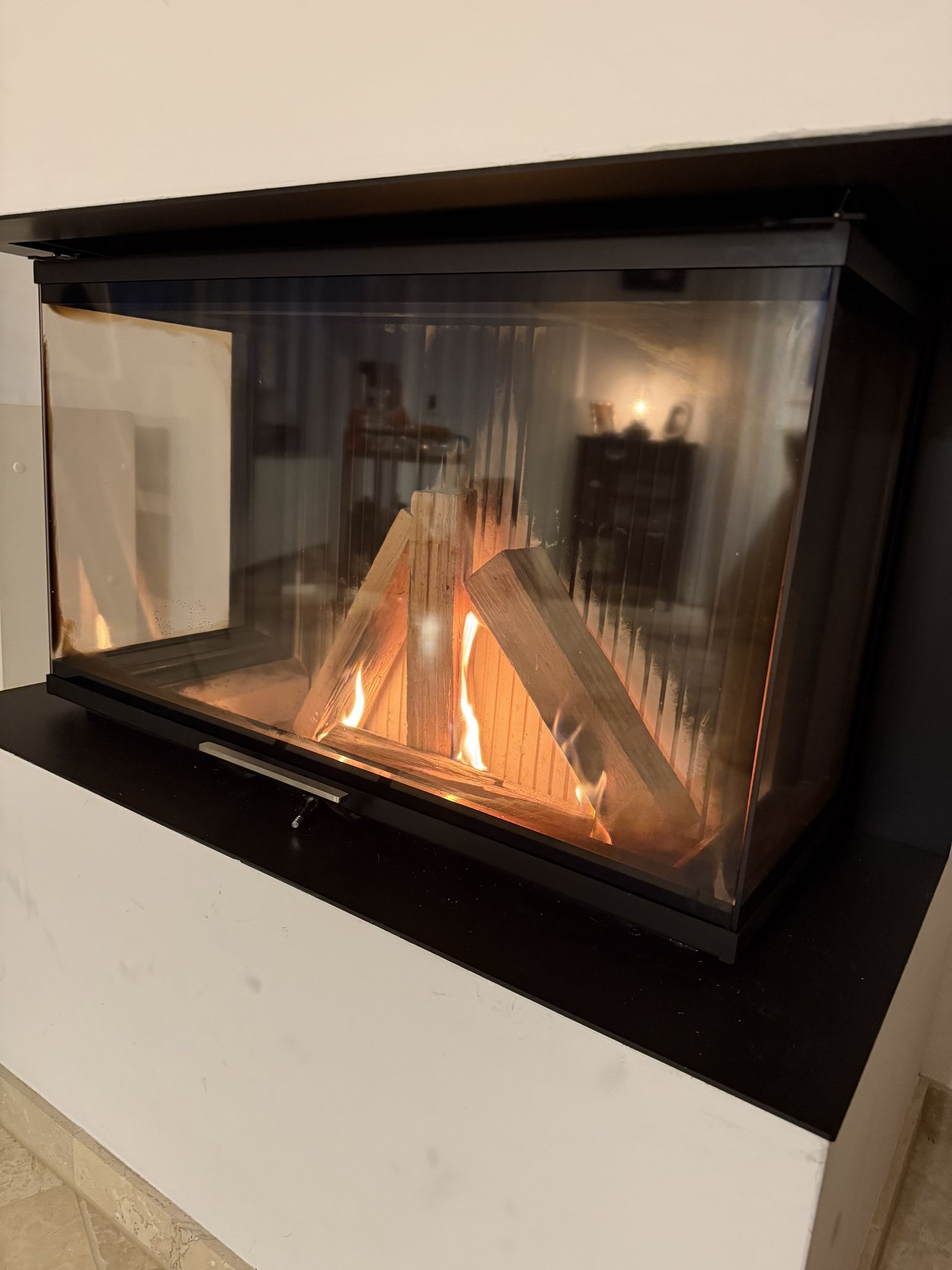 Glass-fronted fireplace in the living room of Villa 77