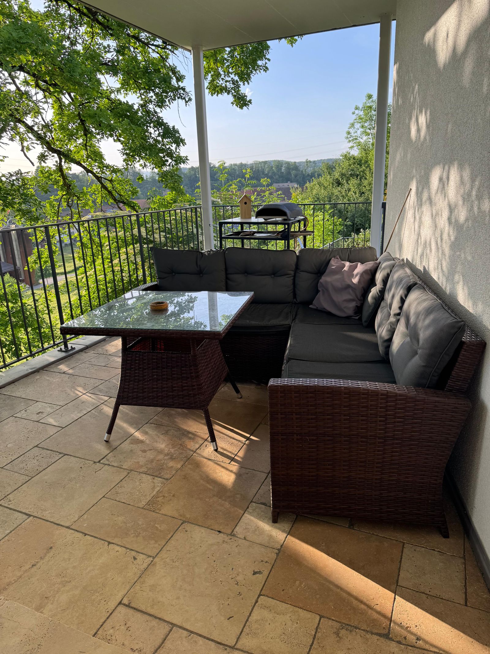 Covered loggia at Villa 77 with lounge seating, gas pizza oven and grill